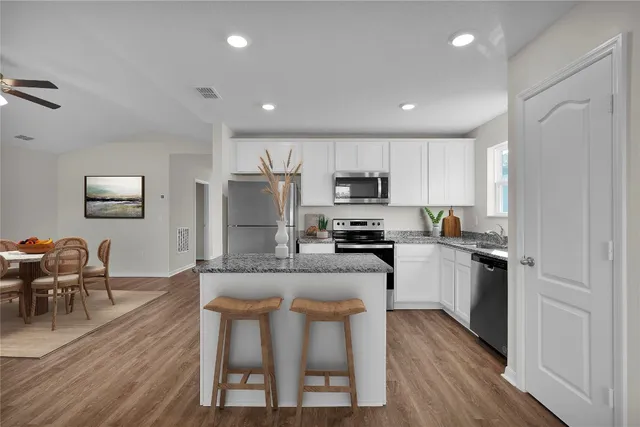 a kitchen with refrigerator a microwave and wooden floor