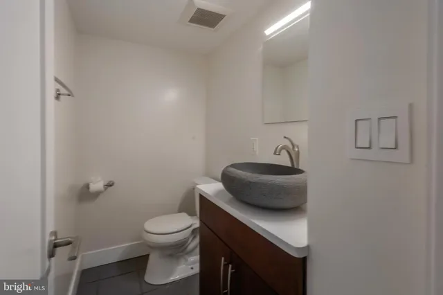 a bathroom with a toilet a sink and a mirror
