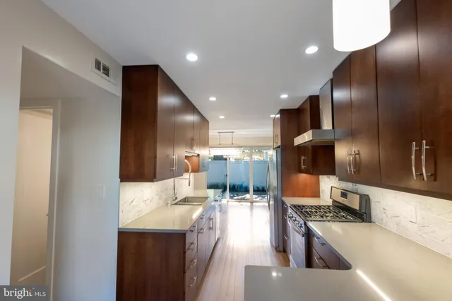 a kitchen with stainless steel appliances kitchen island granite countertop a refrigerator and a stove