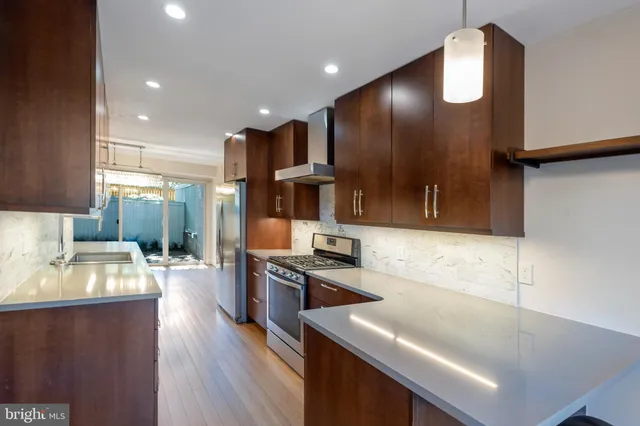 a kitchen with stainless steel appliances granite countertop a sink refrigerator and cabinets