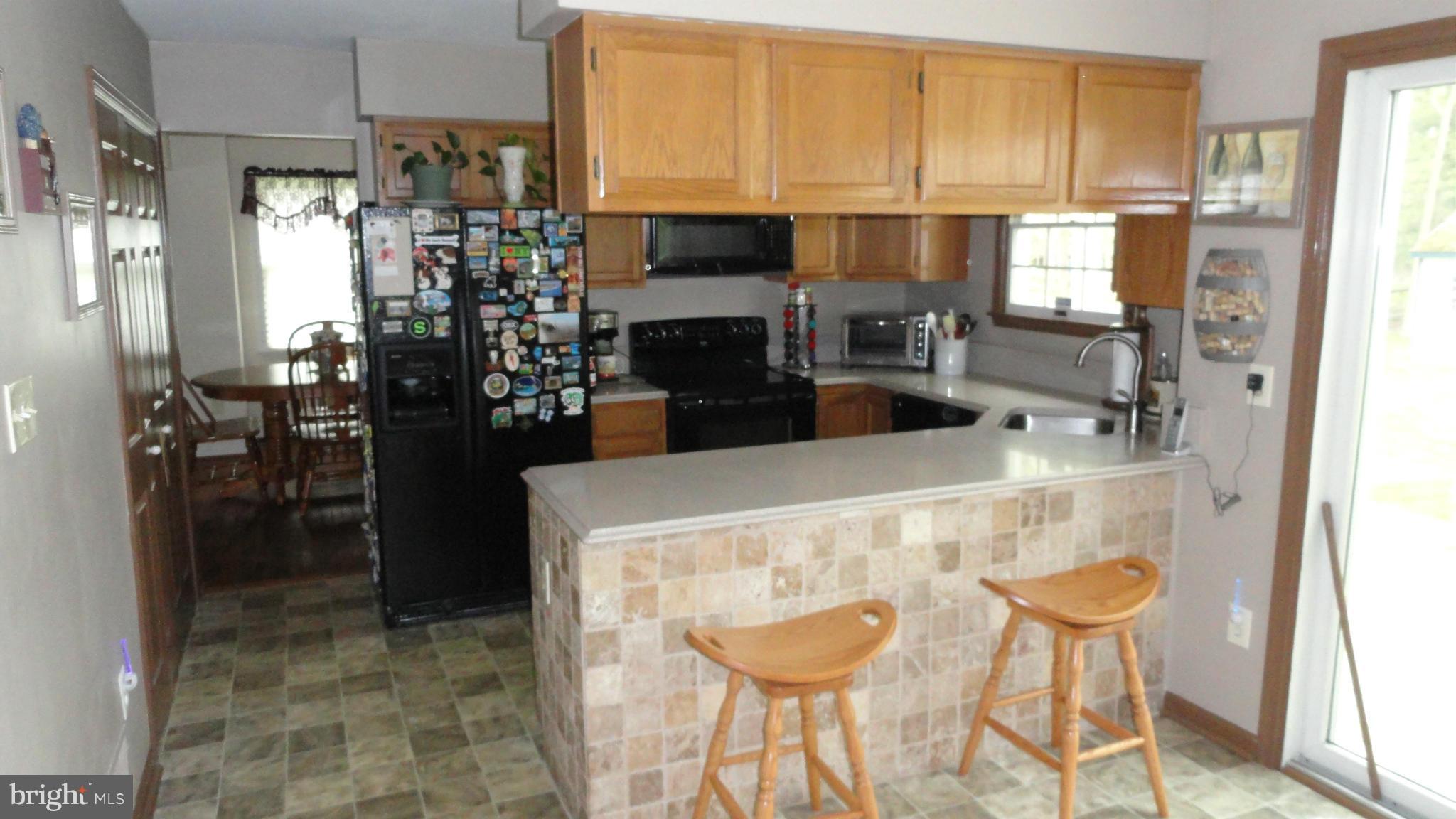 1021 Rodgers Road Churchton, MD 20733 - Photo 10 of 29 a kitchen with a refrigerator and a stove top oven
