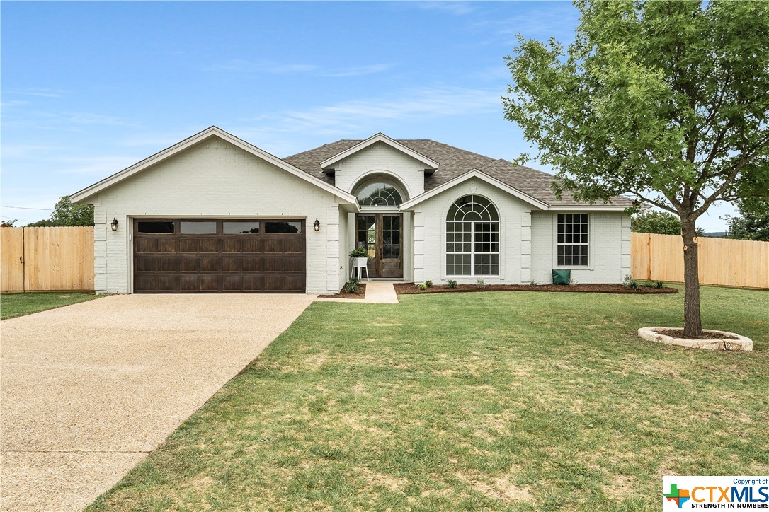 a front view of a house with a garden and yard