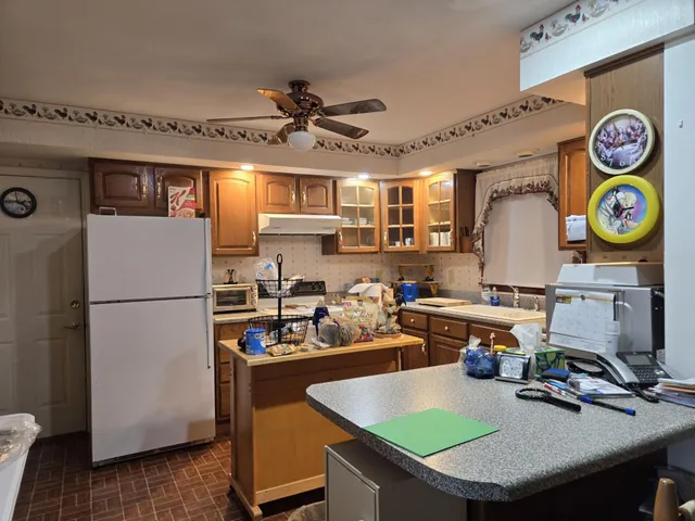 a kitchen with a refrigerator and a stove top oven