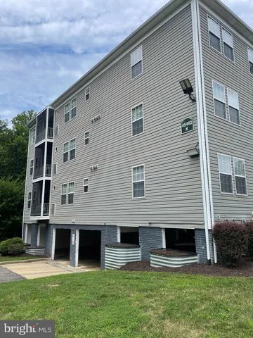a front view of a house with a yard and a large tree