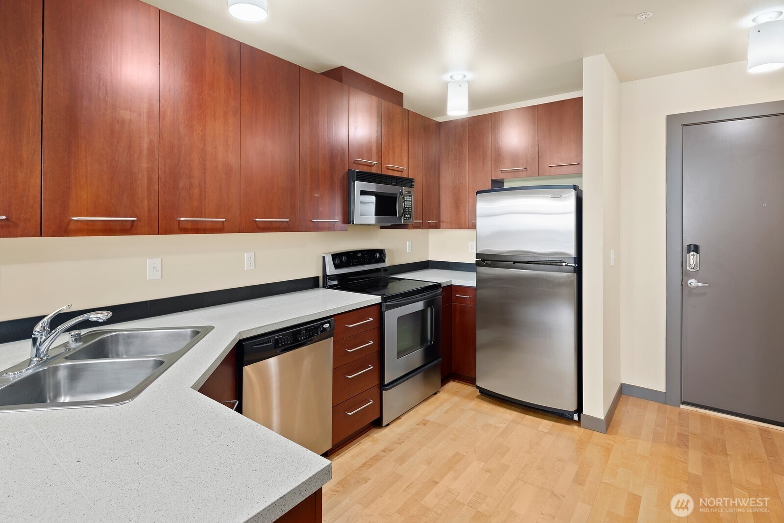 655 Crockett Street, Unit A305 Seattle, WA 98109 - Photo 3 of 23 a kitchen with stainless steel appliances granite countertop a sink a stove and refrigerator