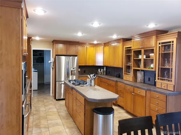 a kitchen with kitchen island granite countertop a sink stove and refrigerator