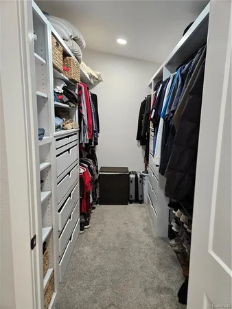 a view of walk in closet with clothes and shoes