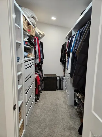 a view of walk in closet with clothes and shoes