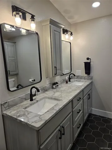 a bathroom with double vanity sinks and a mirror