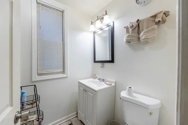 a bathroom with a toilet sink and mirror