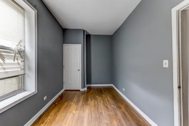 a view of a room with wooden floor and window