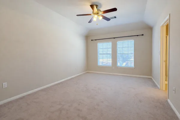 an empty room with windows and fan