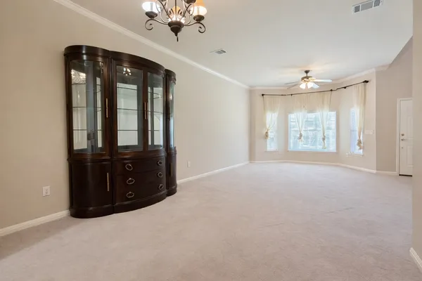 en empty room with windows and cabinet