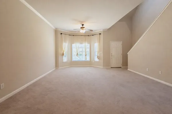 an empty room with windows and chandelier