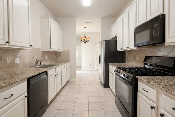 a kitchen with stainless steel appliances granite countertop a stove a refrigerator and a microwave