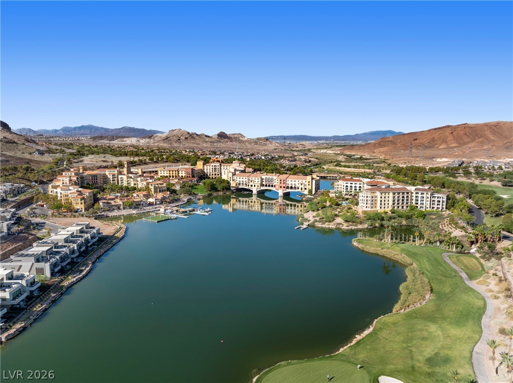 45 Garibaldi Way Henderson, NV 89011 - Photo 70 of 74 Panoramic views encompass a lakeside village, rugged mountains, and a meticulously manicured golf course.