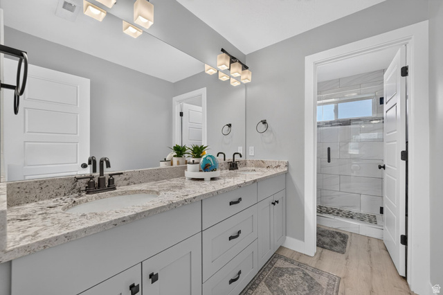 3644 Spiral Springs Road Tooele, UT 84074 - Photo 20 of 41 Double vanity with integrated sinks, light-toned countertop, and matte black fixtures