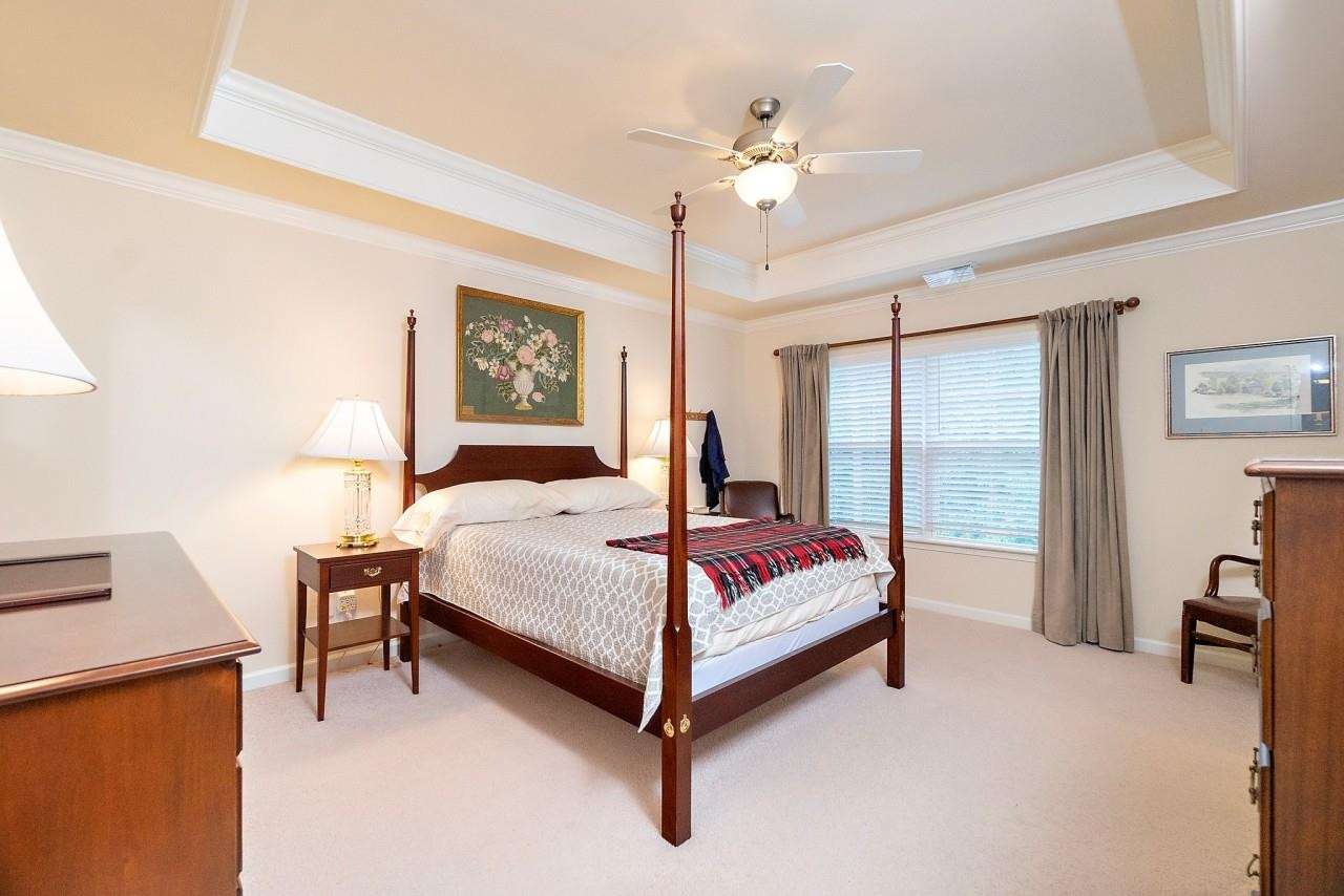 2033 Weston Green Loop Cary, NC 27513 - Photo 11 of 24 a bedroom with a bed lamp and a chandelier