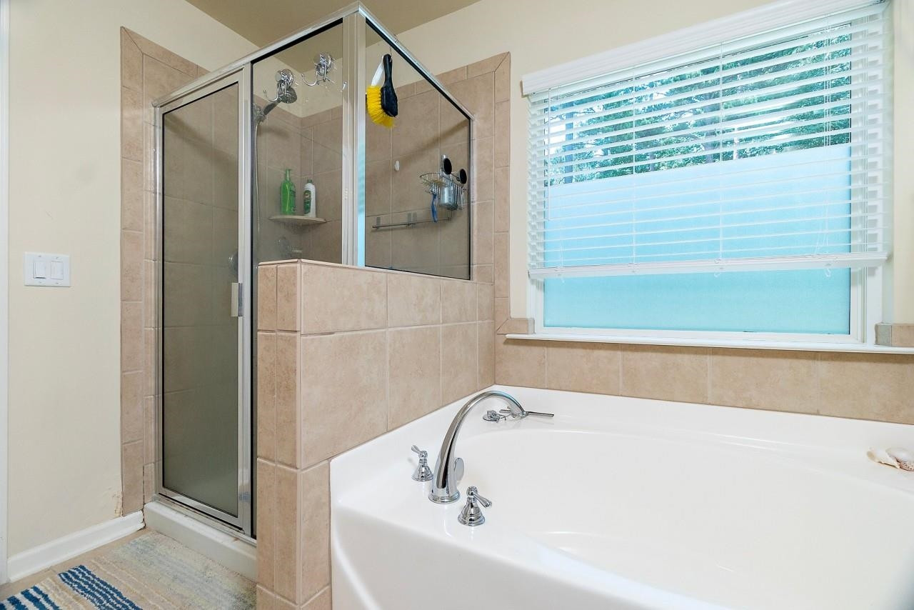 2033 Weston Green Loop Cary, NC 27513 - Photo 15 of 24 a bathroom with a bathtub and a shower
