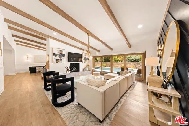 a living room with furniture a large window and a flat screen tv