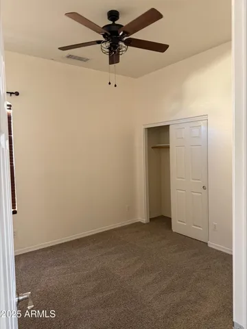 a view of a house with a barbeque and wooden fence
