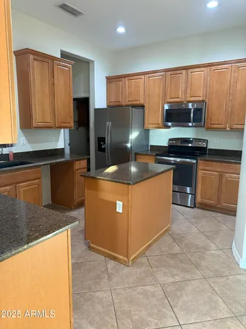 a kitchen with stainless steel appliances granite countertop a stove a sink dishwasher a refrigerator and a microwave