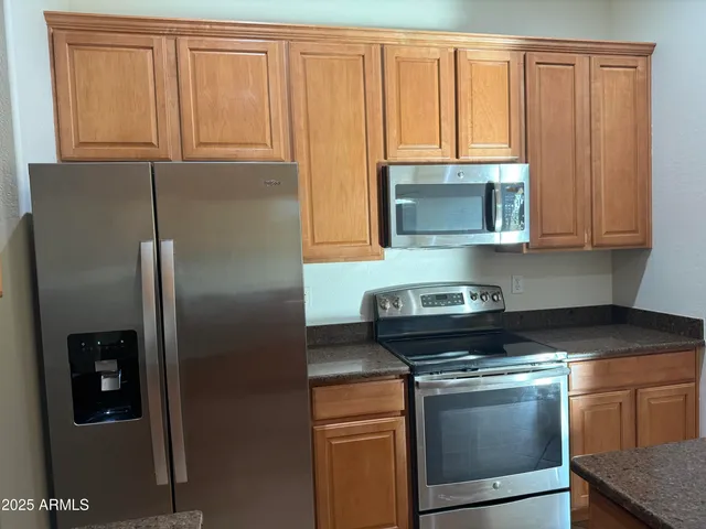 a kitchen with granite countertop cabinets stainless steel appliances and a counter space