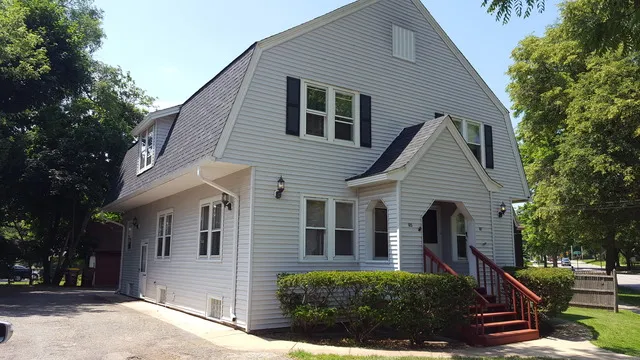 a view of a house with a yard and large tree