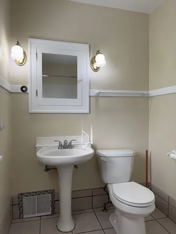 a bathroom with a toilet sink and mirror