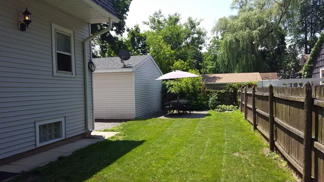 a view of a house with backyard and sitting area