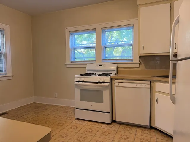a kitchen with a stove cabinets and a window