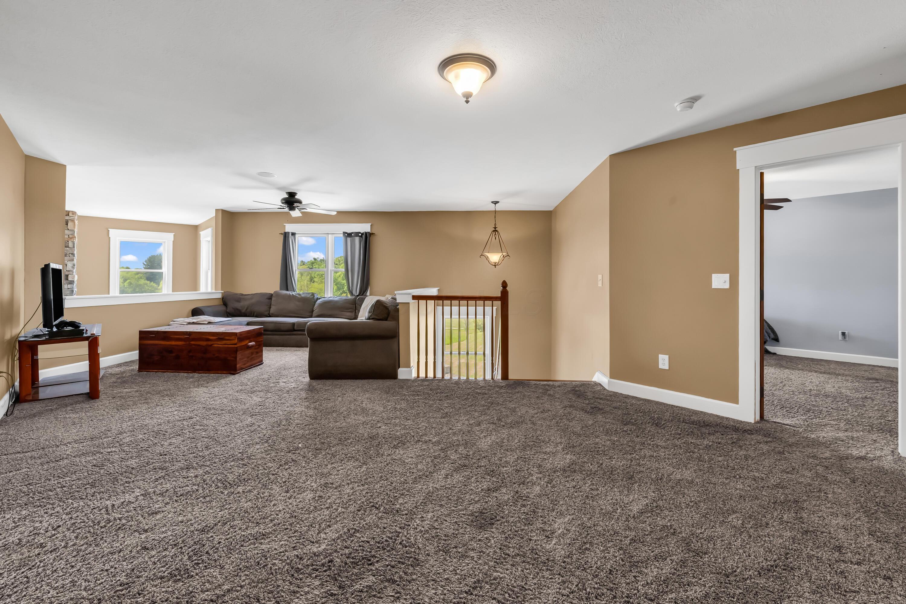 16689 Bailor Road Laurelville, OH 43135 - Photo 31 of 73 • Light sand carpet
• Tan painted walls
• Ceiling fan
• (2) ceiling lights
• 1/2 wall overlooks
Great Room