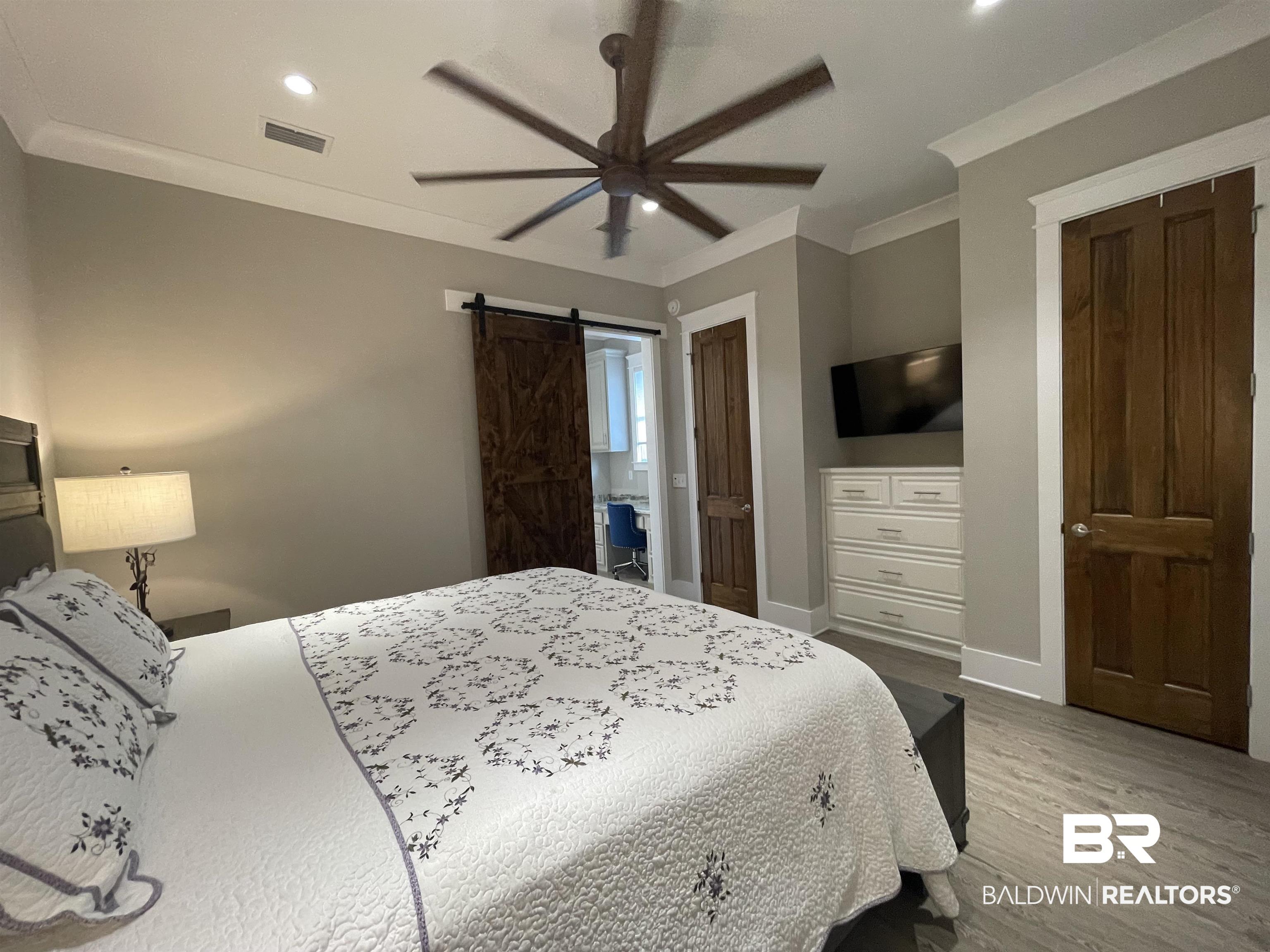 6 Fairhope Motorcoach Loop Fairhope, AL 36532 - Photo 15 of 33 Bedroom with ornamental molding, hardwood / wood-style flooring, ceiling fan, and a barn door