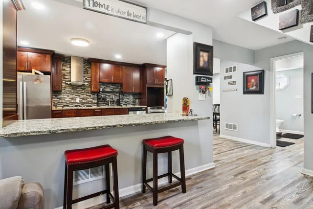 a kitchen view with wooden floor and electronic appliances