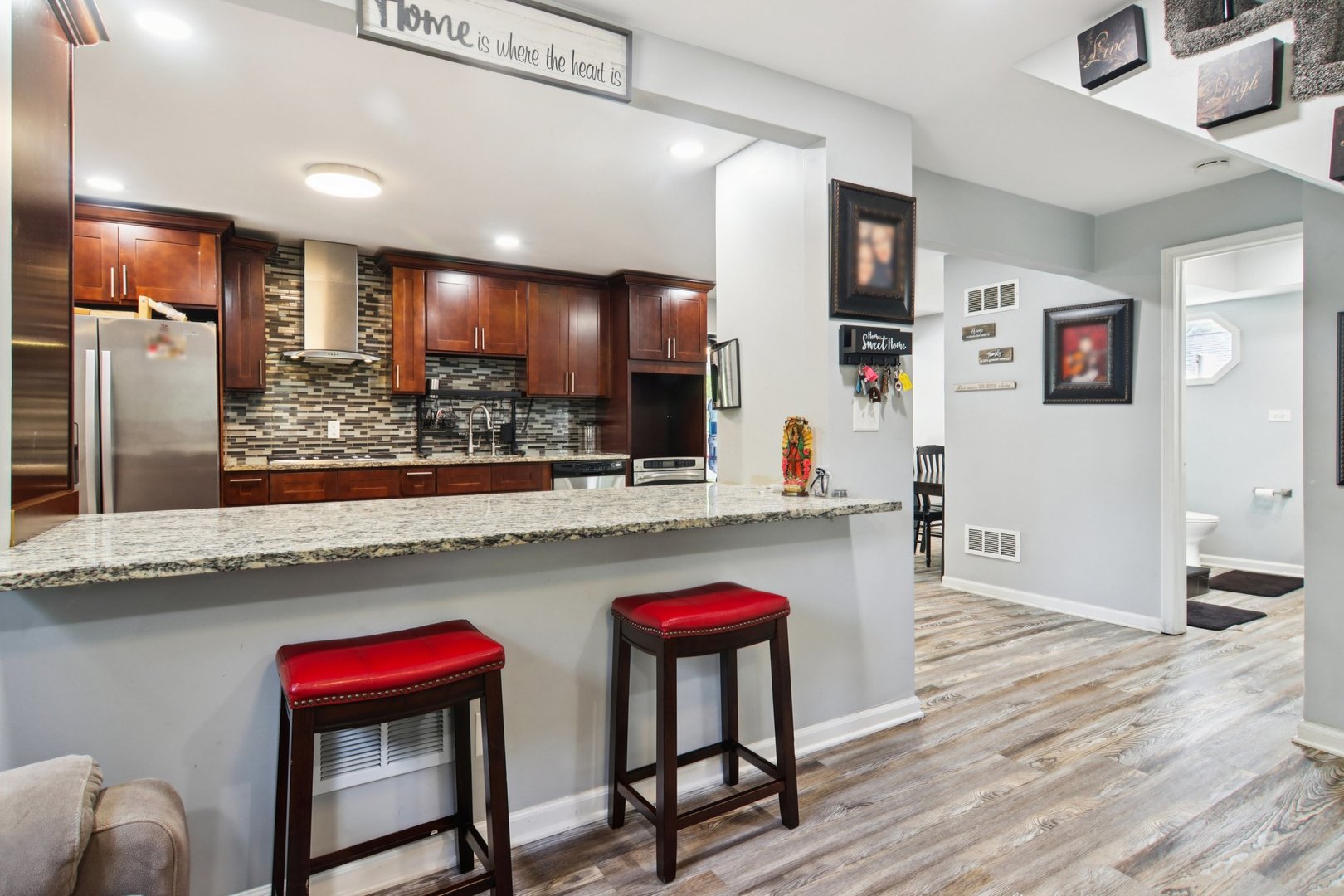 806 Spencer Street Joliet, IL 60433 - Photo 12 of 49 a kitchen with stainless steel appliances granite countertop a kitchen island and chairs in it