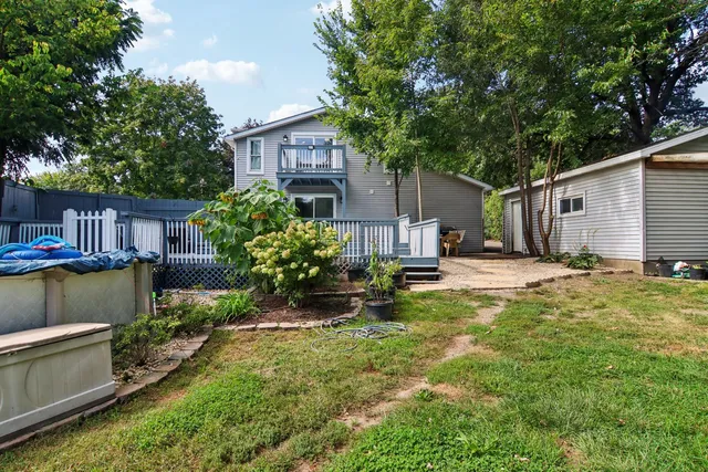 a view of a green field with plants in front of house