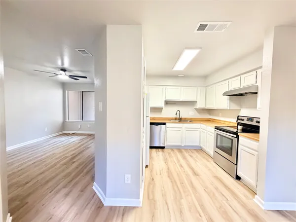 a kitchen with a refrigerator and white cabinets