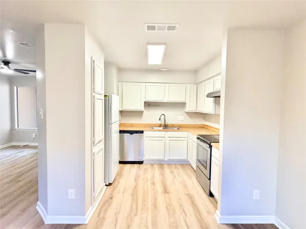 a kitchen with a sink a counter top space and stainless steel appliances