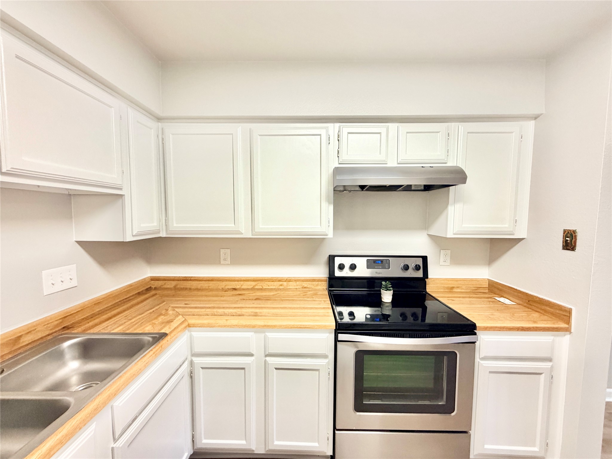 1730 Timber Ridge Road, Unit 152 Austin, TX 78741 - Photo 15 of 26 Kitchen featuring stainless steel electric range oven, white cabinets, and under cabinet range hood