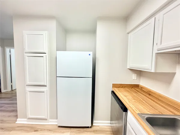 a white refrigerator freezer and a stove sitting inside of a kitchen