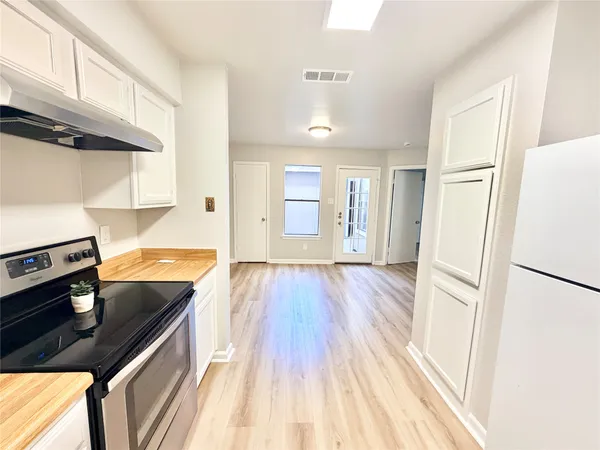 a kitchen with a refrigerator and a stove top oven