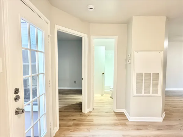 hallway view with wooden floor and bathroom view