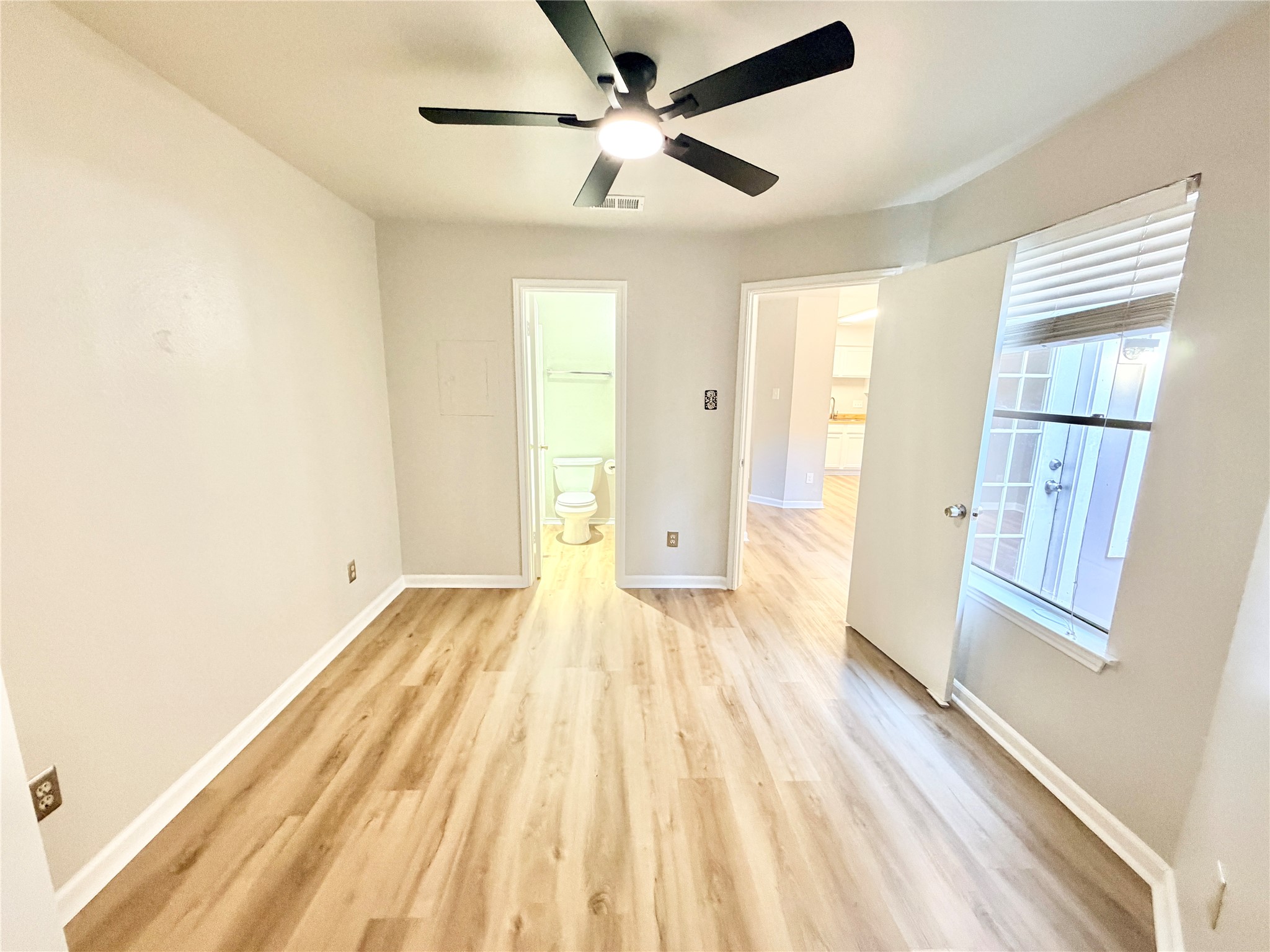 1730 Timber Ridge Road, Unit 152 Austin, TX 78741 - Photo 21 of 26 Unfurnished bedroom with light wood-style flooring, a ceiling fan, and ensuite bath