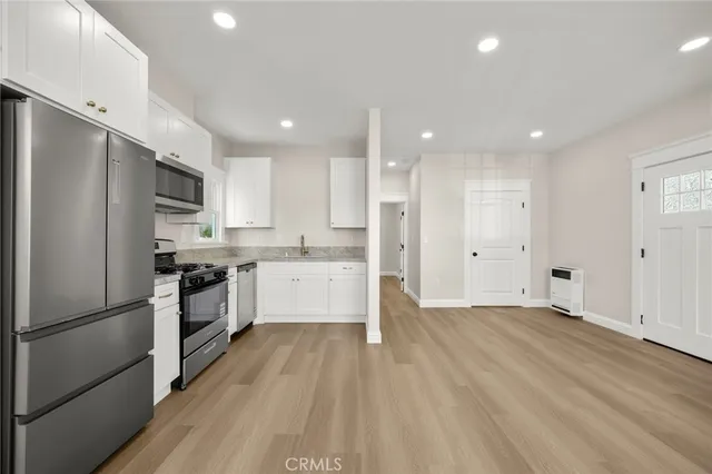 a bathroom with a granite countertop sink toilet a mirror and shower