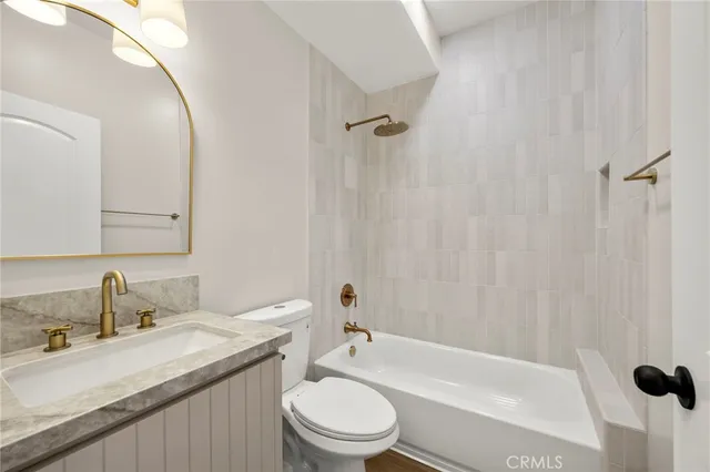 a bathroom with a granite countertop sink a toilet and a mirror