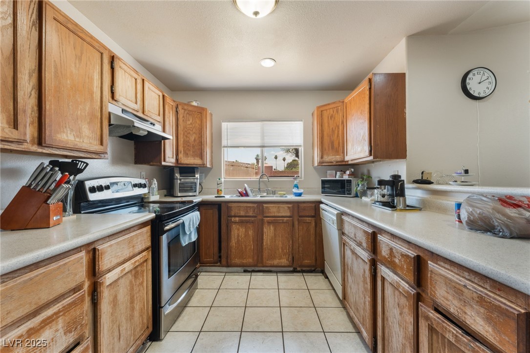 4656 East Desert Inn Road Las Vegas, NV 89121 - Photo 42 of 98 4650 E DI Kitchen with stainless steel electric stove, under cabinet range hood, dishwasher, and light countertops