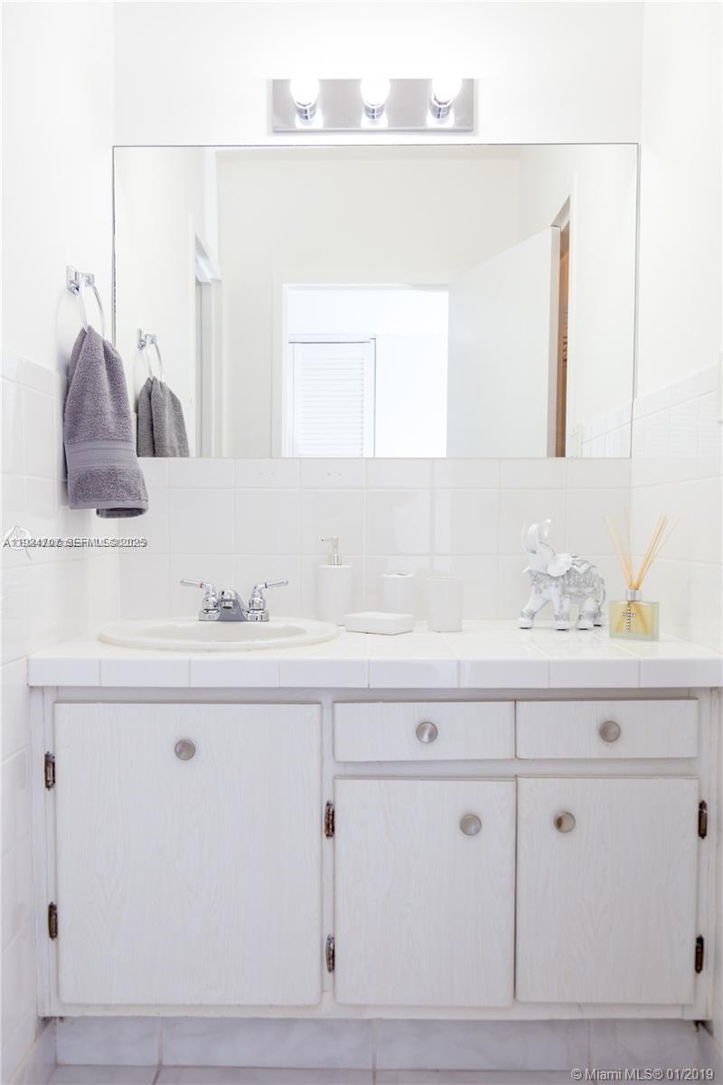 100 Lincoln Road, Unit 1216 Miami Beach, FL 33139 - Photo 4 of 7 a bathroom with a sink vanity and mirror