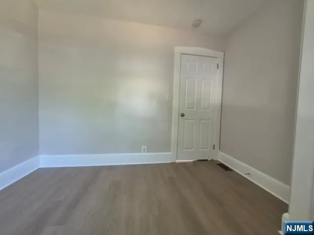 an empty room with wooden floor and window
