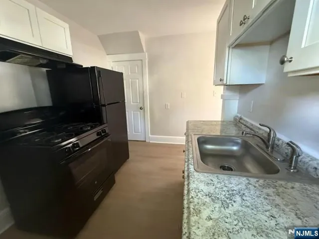 a kitchen with kitchen island a sink stove and refrigerator