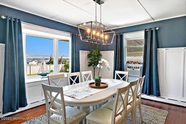 a dining room with furniture a chandelier and wooden floor